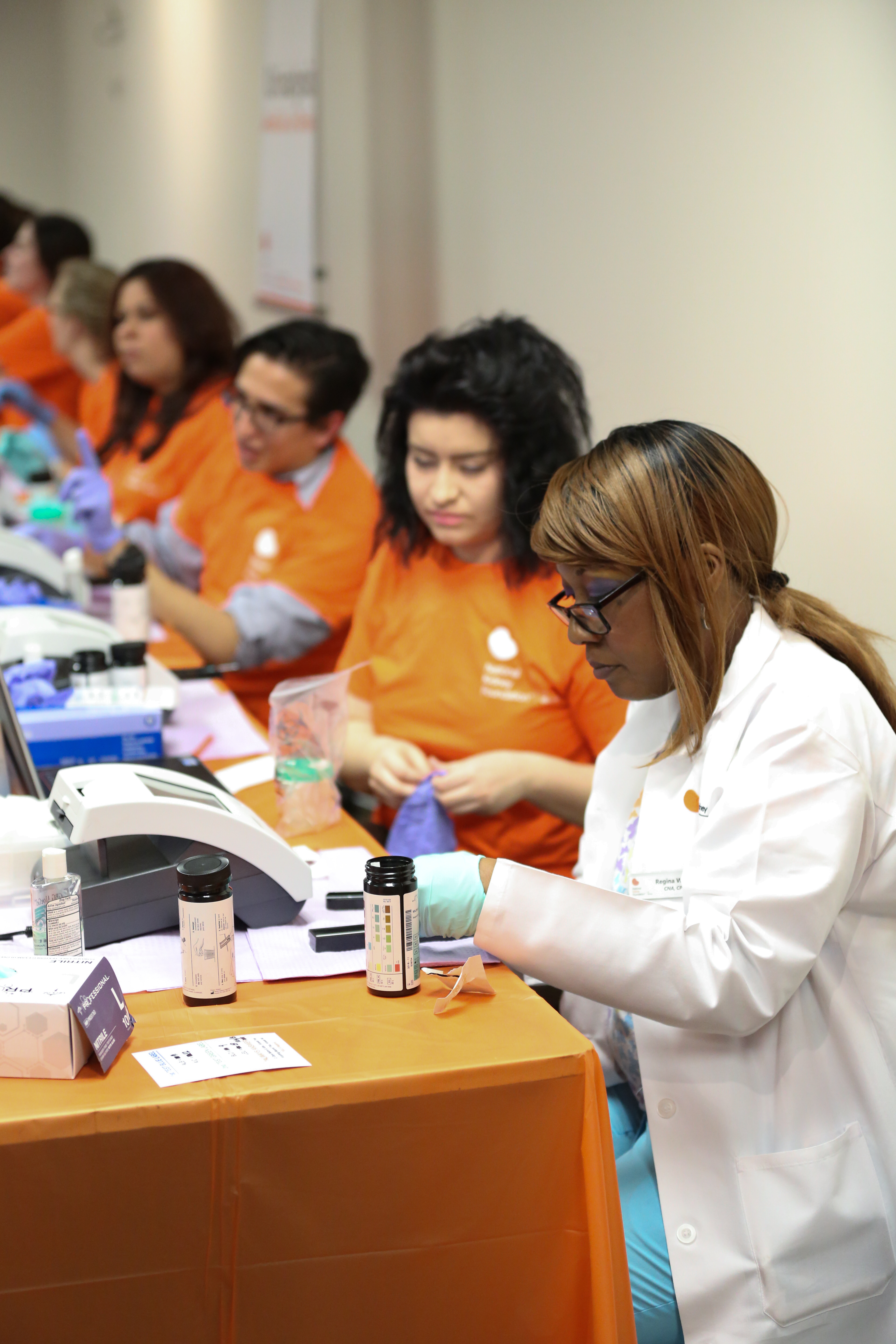 Photo of NKFI employees and volunteers conducting kidney health screenings.