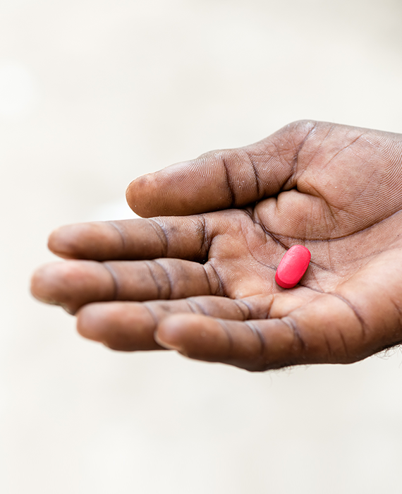 Hand holding a single pill