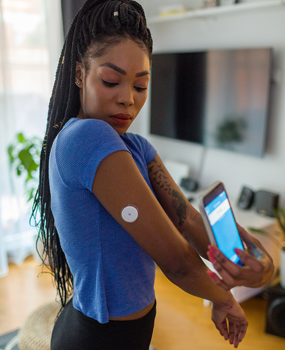 Black woman's hands, testing her blood sugar with an at-home blood sugar monitor