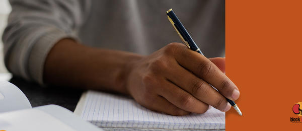 Image of a hand holding a pen, hovered over a blank notebook