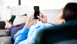 woman on couch look her phone