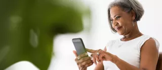 Woman looks at her phone, smiling