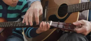 2 people learn the guitar