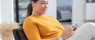 woman sitting looking at her phone