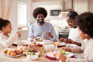 Photo of a smiling family enjoying dinner together