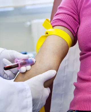 Close of up blood being drawn by a medical professional from a woman's arm