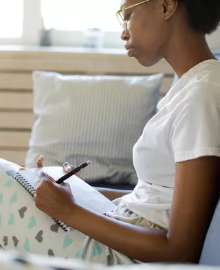 Photo of a woman writing in her journal.