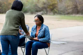 Photo of a woman handing out flyers to another woman